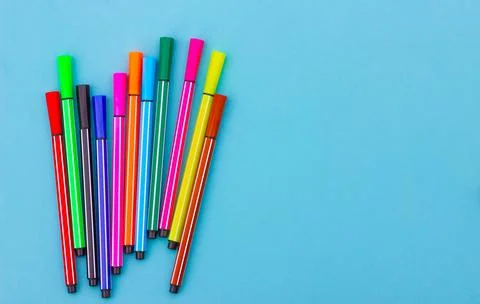Multicolored markers on a blue background. Stock Photos