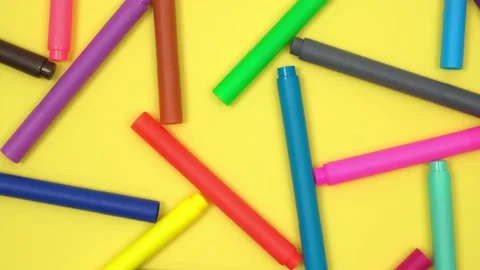 Multicolored markers randomly lie on rotating yellow background. back to school. Stock Footage 238836766