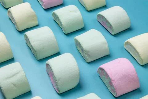 Multicolored marshmallows on a blue background Stock Photos