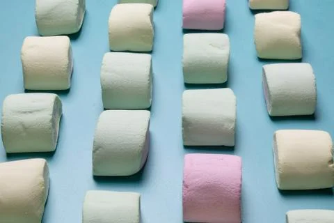 Multicolored marshmallows on a blue background Stock Photos