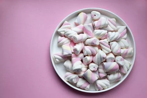 Multicolored marshmallows on a plate. Background or texture of blue and pin.. Stock Photos