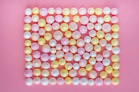 Multicolored meringues made in the shape of a rectangle on a pink background Stock Photos