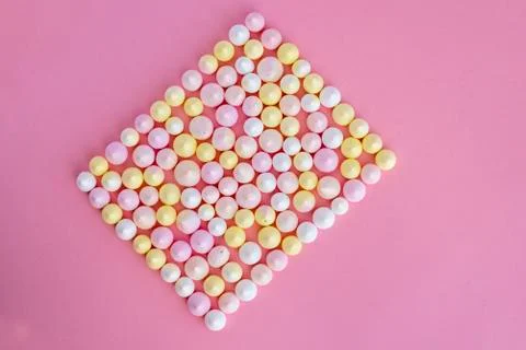 Multicolored meringues made in the shape of a rectangle on a pink background Stock Photos