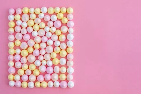 Multicolored meringues made in the shape of a rectangle on a pink background 스톡 사진