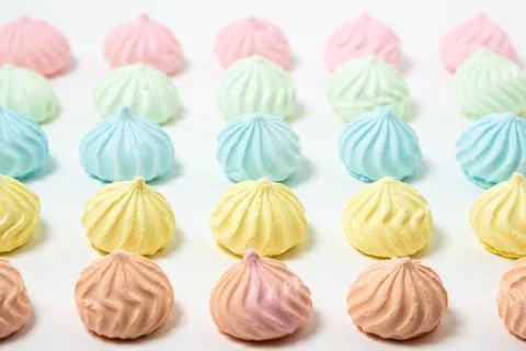 Multicolored meringues on a white background Stock Photos
