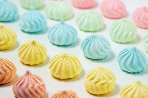 Multicolored meringues on a white background Stock Photos