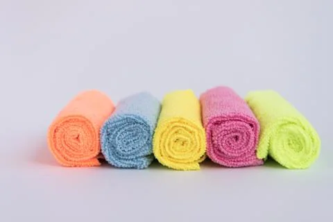 Multicolored microfiber cloths, folded into rollers. The fabrics are laid out Stock Photos