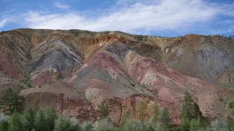 Multicolored mountains. Timelapse. Red and yellow hill. Blue sky with light Stock Footage 108588070