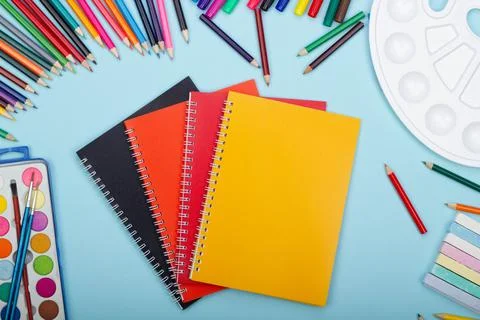 Multicolored notebooks, black, red and orange, art school supplies for painting Stock Photos