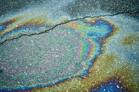 A multicolored oil slick creates dynamic patterns on wet asphalt, beautifully Stock Photos