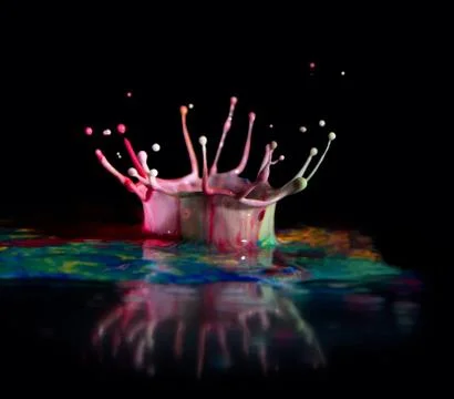 Multicolored paint drops create abstract puddle and crown with drops, splashes Stock Photos