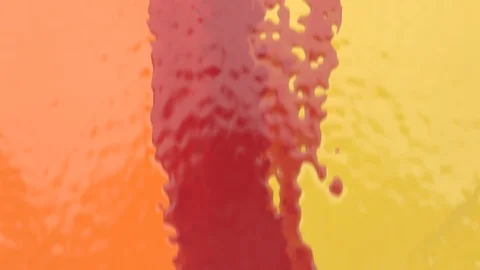 Multicolored paint in red, orange and yellow tones flowing down wall (FULL HD) 스톡 동영상 110813623