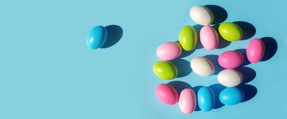 Multicolored painted Easter eggs on blue paper background. Flat lay  top view Stock Photos