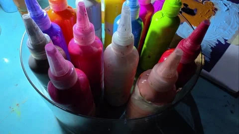 Multicolored paints in tubes are on the table under a lamp in the evening. Stock Footage 300066462