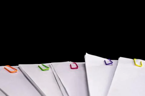 Multicolored paper clips on paperwork Stock Photos