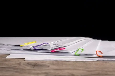 Multicolored paper clips on paperwork Stock Photos