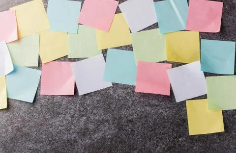 Multicolored paper stick note list on concrete wall Stock Photos