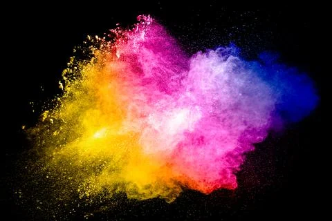 Multicolored particle exploding on black background. Colorful dust splashing. Stock Photos