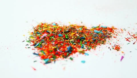 Multicolored particles of colored pencils on white background Stock Photos