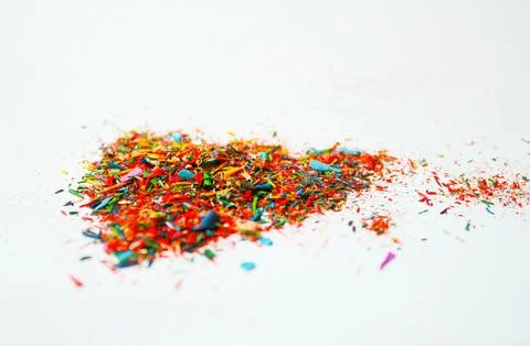Multicolored particles of colored pencils on white background Stock Photos