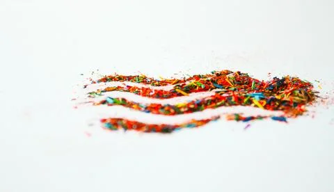 Multicolored particles of colored pencils on white background Stock Photos