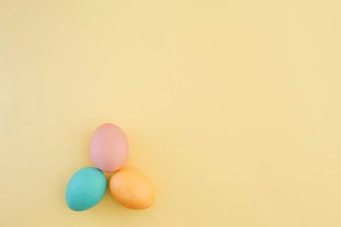 Multicolored pastel easter eggs on trendy yellow background with place for text Stock Photos