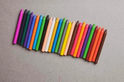 Multicolored pastelCrayons on grey background. Flat lay, nobody Stock Photos