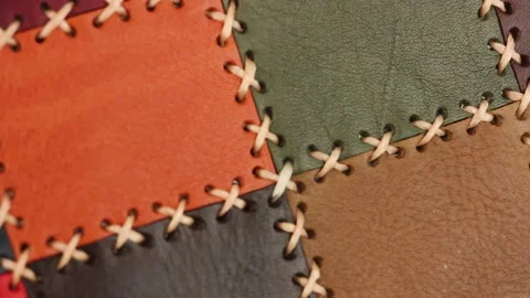 Multicolored patchwork leather surface with large stitching moves, close-up view Video stock 156474621