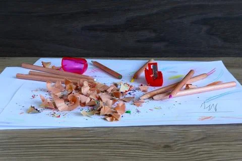 Multicolored pencils on a light background next to shavings and pencils Stock Photos