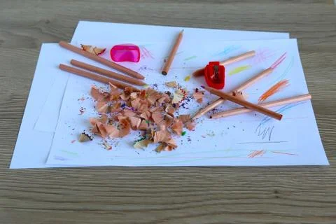 Multicolored pencils on a light background next to shavings and pencils 库存照片