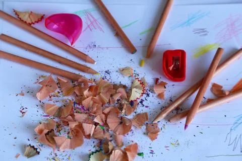 Multicolored pencils on a light background next to shavings and pencils Stock Photos