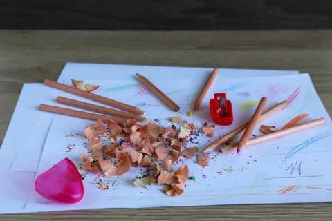 Multicolored pencils on a light background next to shavings and pencils Stock Photos