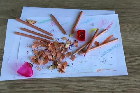 Multicolored pencils on a light background next to shavings and pencils Stock Photos