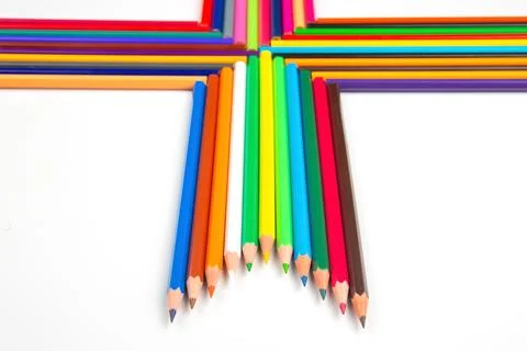 Multicolored pencils lined up in a dynamic wave formation on a white backdr.. Stock Photos
