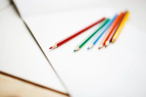Multicolored pencils lying on a white table Stock Photos