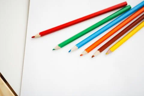 Multicolored pencils lying on a white table 스톡 사진