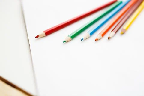 Multicolored pencils lying on a white table Foto stock