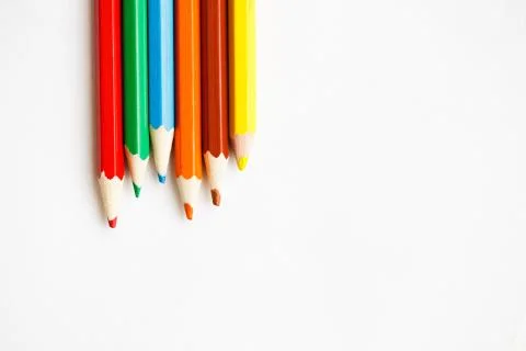 Multicolored pencils lying on a white table Stock Photos