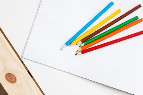 Multicolored pencils lying on a white table Stock Photos