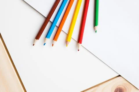 Multicolored pencils lying on a white table Foto stock