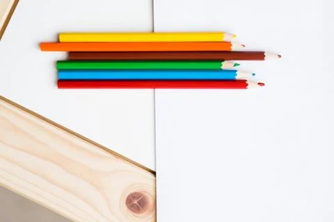 Multicolored pencils lying on a white table Stock Photos