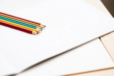 Multicolored pencils lying on a white table 스톡 사진