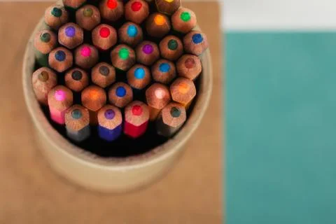 Multicolored pensils in the box on a blue background Stock Photos