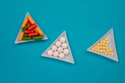 Multicolored pills are scattered on the table. Top view with copy space, flat Stock Photos