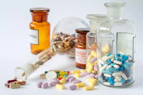 Multicolored pills in flasks on a white background. Stock Photos