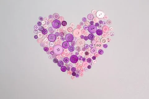 Multicolored pink thread spools and buttons on white background Stock Photos