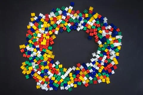 Multicolored plastic blocks on a black background with a place for text. Part Foto stock