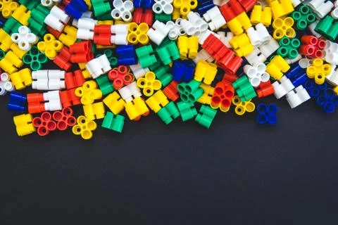 Multicolored plastic blocks on a black background with a place for text. Part Stock Photos