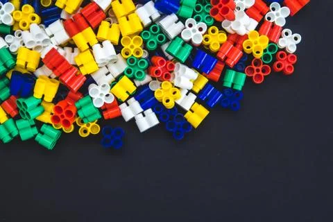 Multicolored plastic blocks on a black background with a place for text. Part Stock Photos