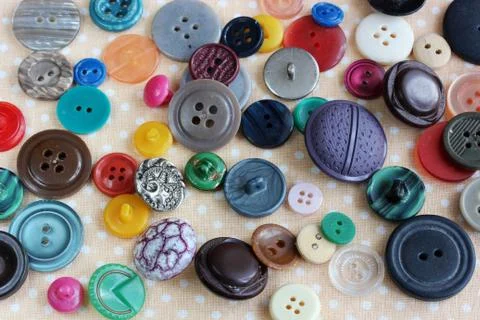 Multicolored plastic buttons scattered, view from above. Foto stock